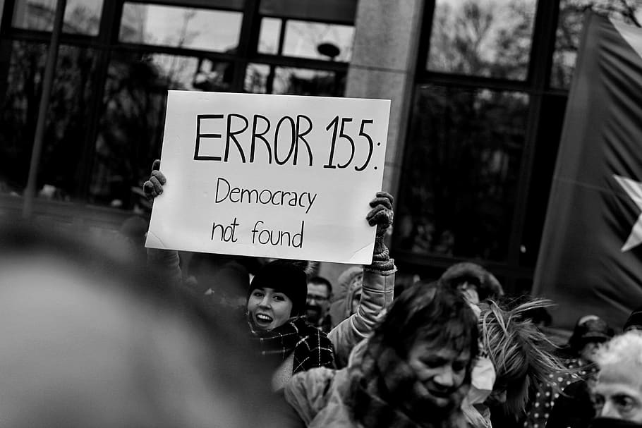 person holding a white Error 155 signage, person holding Error 155: Democracy Not Found banner, HD wallpaper