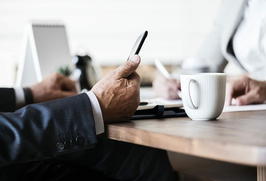 person leaning on table beside white cup on tabletop, coffee HD wallpaper