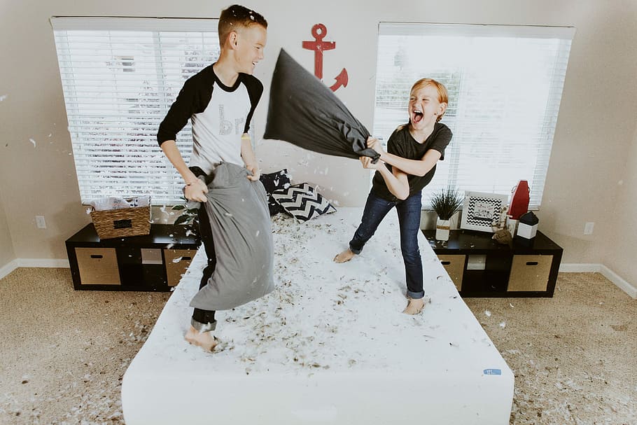 boy and girl having pillow fight, boy and girl holding gray pillows HD wallpaper