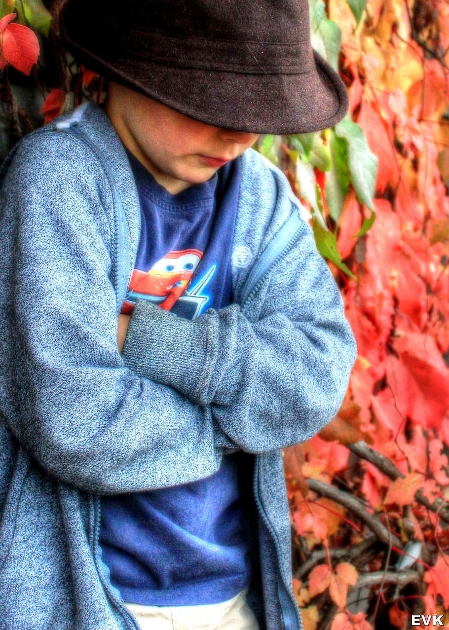 shallow focus photography of boy in black hat and blue cardigan HD wallpaper