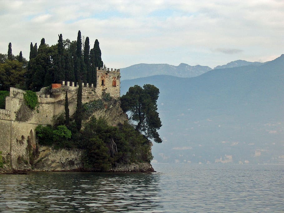 brown stone castle on cliff near body of water during daytime HD wallpaper