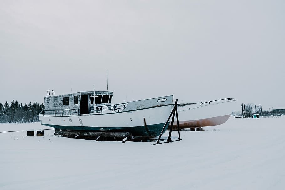 two boats on snow-covered field during daytime, photography of two boats on snow coated ground HD wallpaper