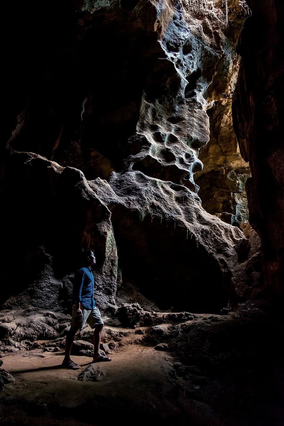 man in blue dress shirt inside the cave, man standing between stones HD wallpaper