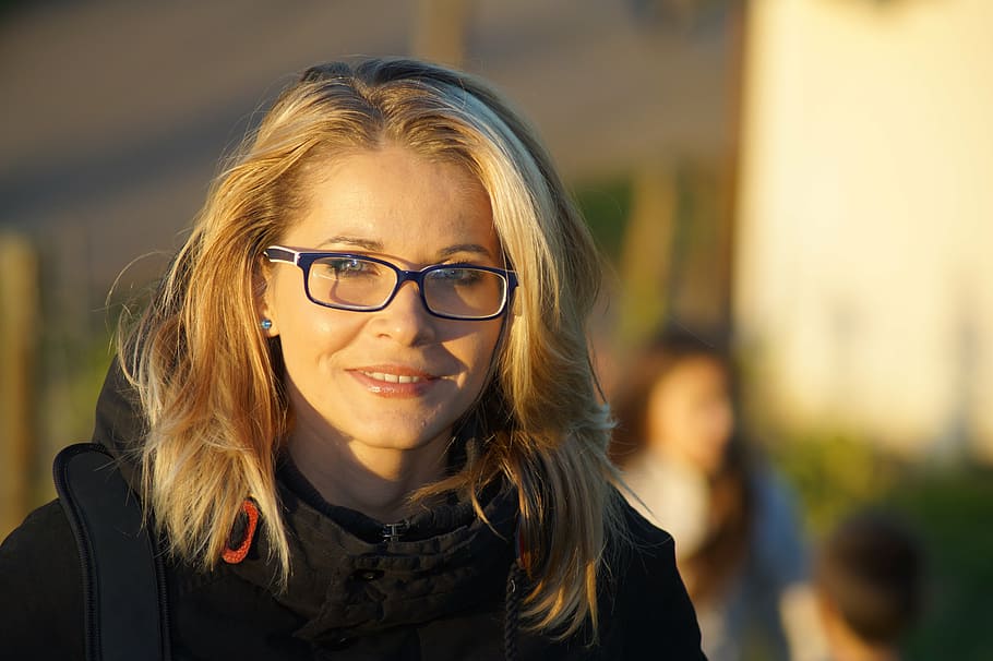 selective focus photography of woman wearing black framed eyeglasses and black coat HD wallpaper