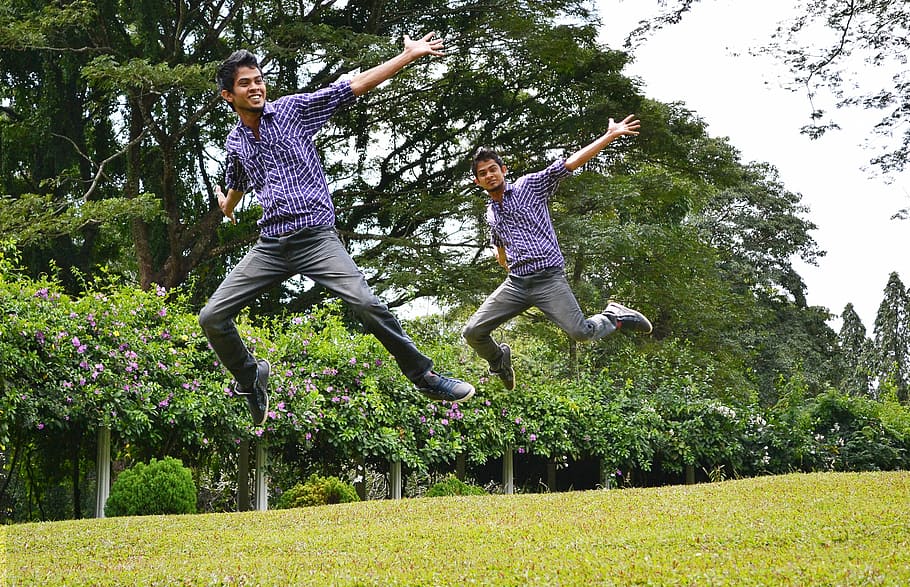 two men in blue shirt jumping on grass field during day, joy HD wallpaper