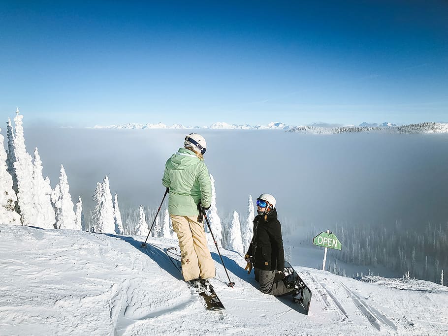 man in green snow jacket and brown pants, two person wearing snowboards on snowfield near trees HD wallpaper