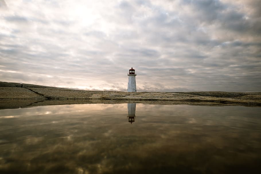 lighthouse reflecting on body of water, white lighthouse under cloudy sky HD wallpaper
