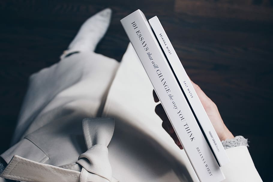 person holding books, white and black cover book, coat, bow, number HD wallpaper
