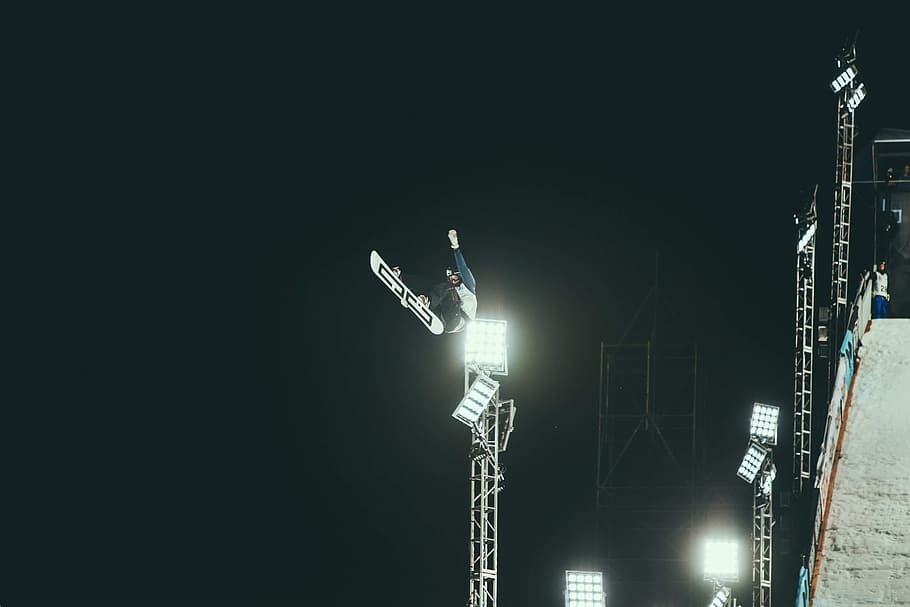 person snowboarding making stunts during nighttime, macro photography of man snowboarding HD wallpaper