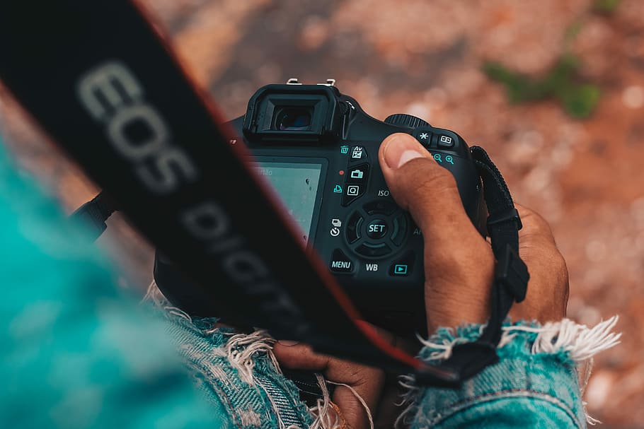 person holding DSLR camera, person holding black Canon EOS camera HD wallpaper