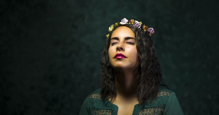 woman in teal top with floral tiara, woman closing her eyes standing against black background HD wallpaper