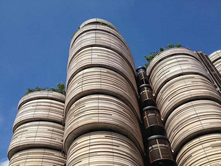 low angle photo of a brown concrete high-rise building under blue sky HD wallpaper