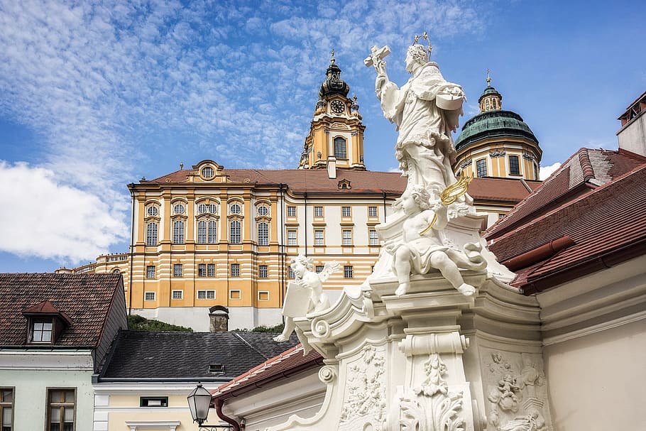 low angle photo of man holding cross statue, melk, austria, monastery