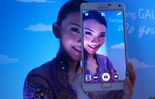person taking photo using white frost Samsung Galaxy Note 4 HD wallpaper