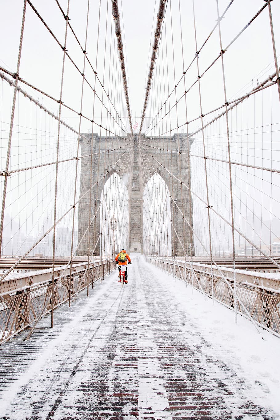 person on red bicycle running on brown bridge covered by snow, person riding bicycle in the middle of snowy bridge HD wallpaper