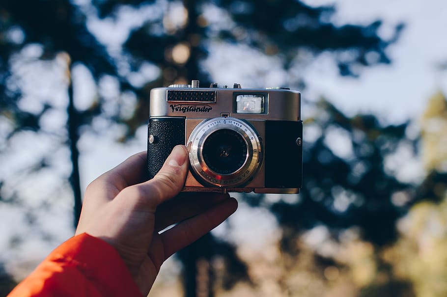 person holding black and gray point-and-shoot camera, shallow focus photo of digital camera HD wallpaper