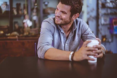 man holding cup on table, man sitting on chair holding white tumbler HD wallpaper
