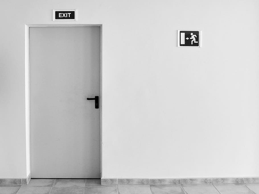 closed white painted door with exit signage, closed door with exit sign