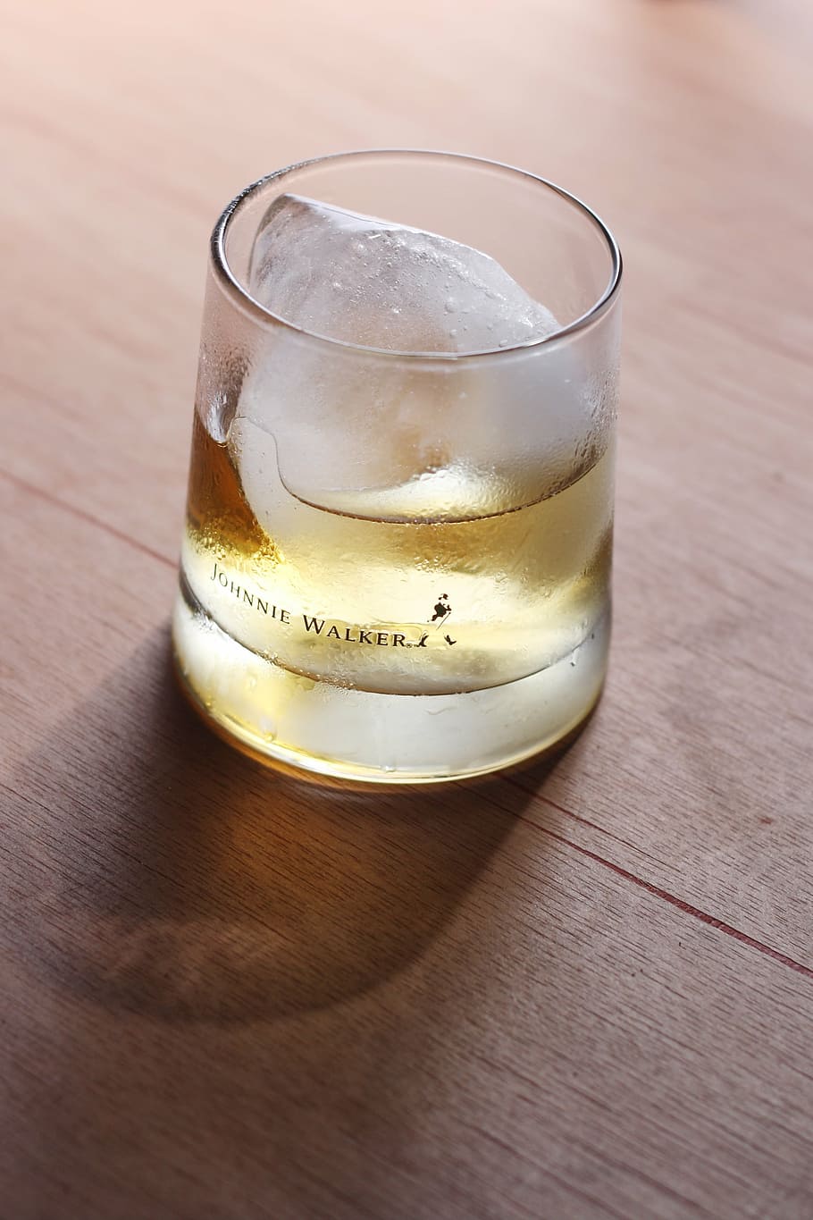 Johnnie Walker glass with beverage with ice, whiskey, whisky
