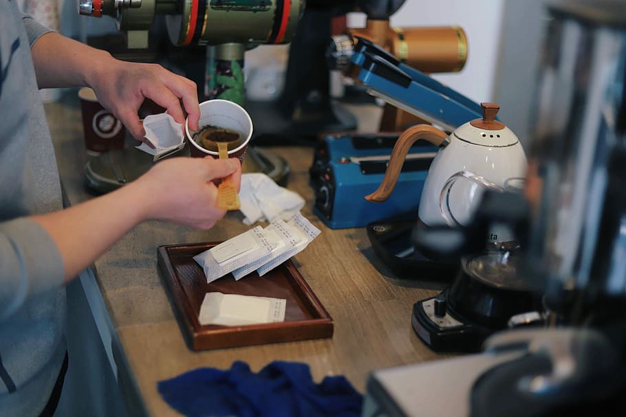 person pouring powder in cup, person scooping coffee while standing HD wallpaper