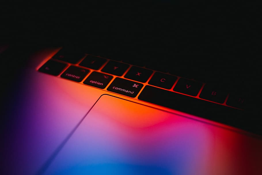 laptop keypad, flat lay photography of MacBook Pro under neon lights