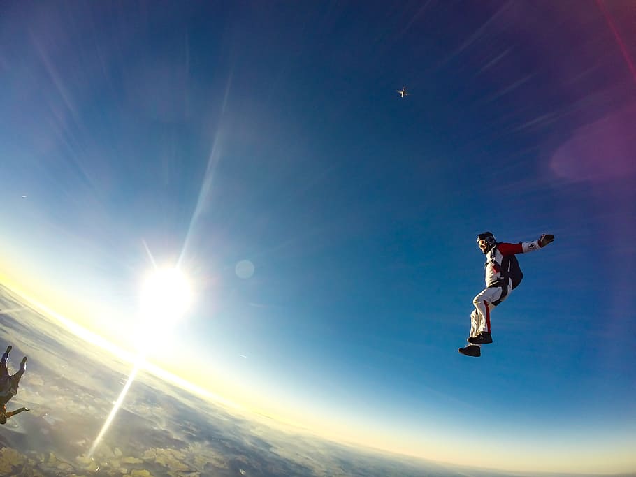man jumping in sky during daytime, time lapse photo of skydiver during daytime HD wallpaper