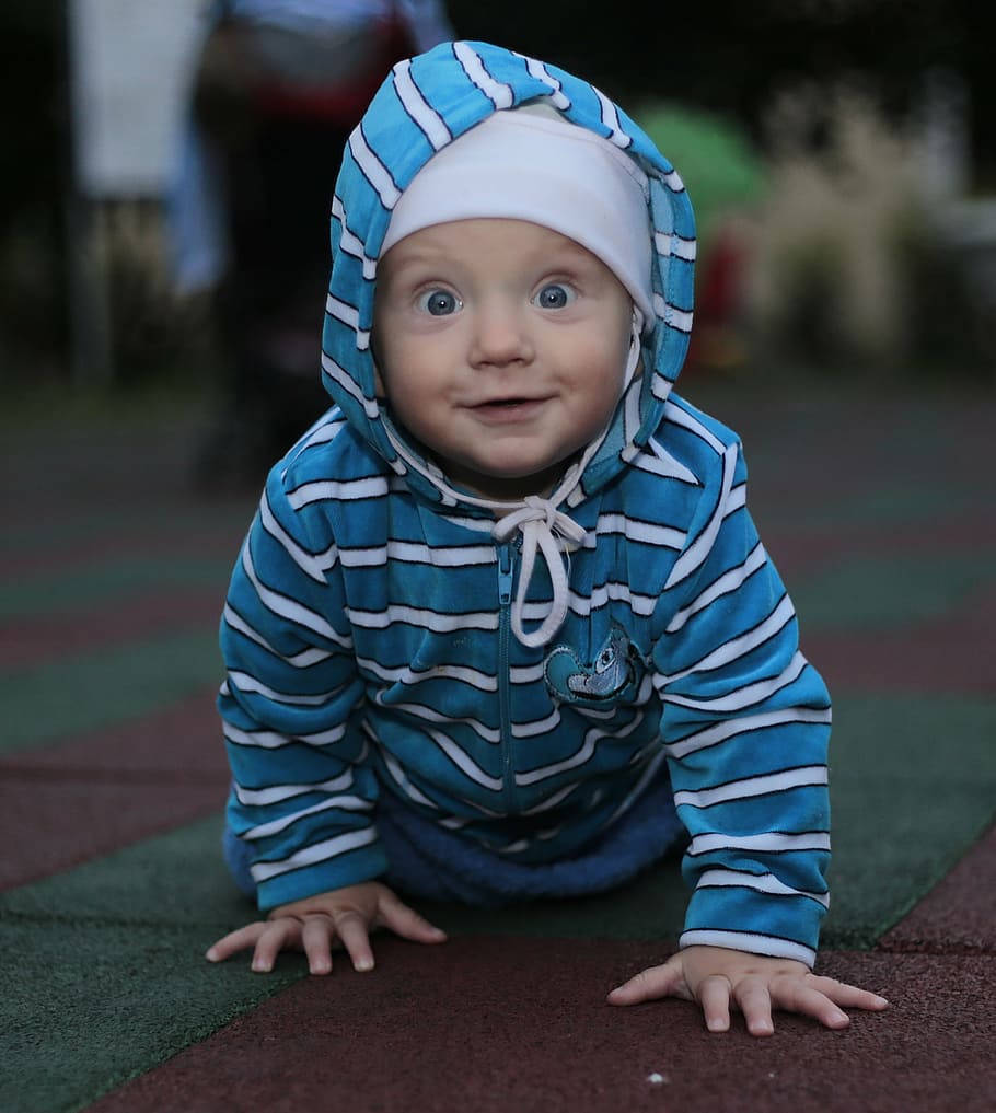 shallow focus photography of baby in blue and white striped jacket