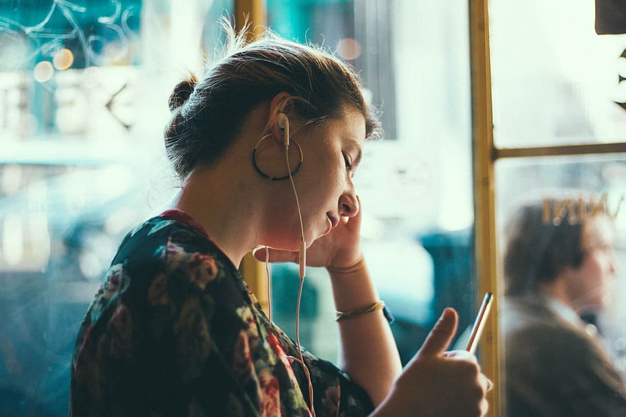 selective focus photography of woman in black and multicolored floral top with white earbuds, HD wallpaper