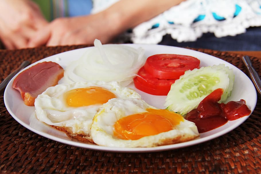 fried eggs; sliced tomatoes; sliced cucumber; and sliced meat on plate HD wallpaper