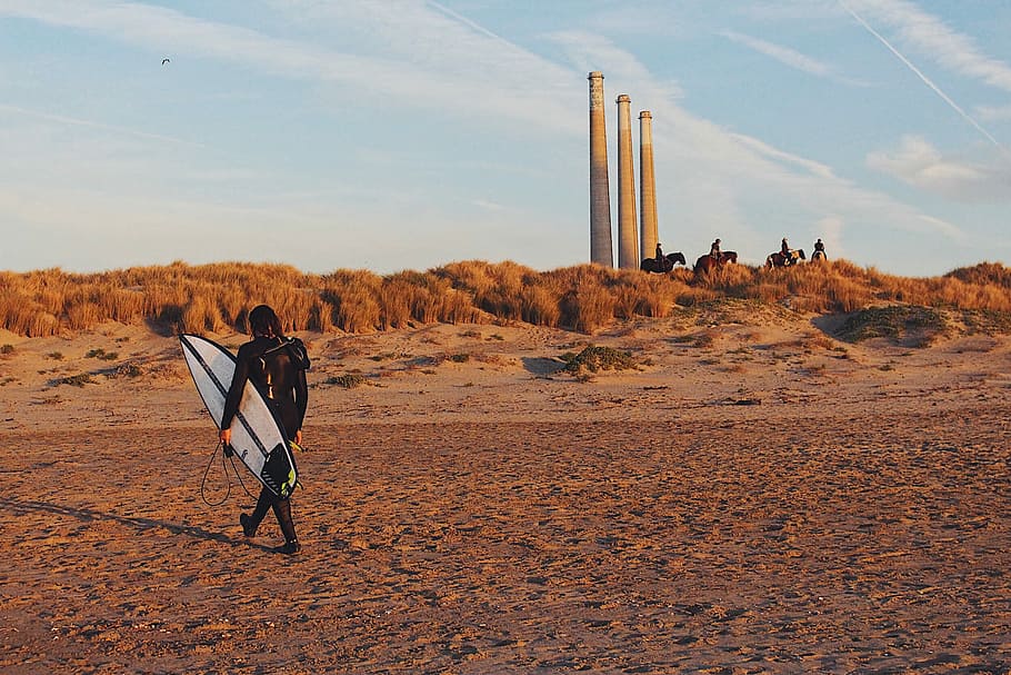 person carrying surfboard on sand, man holding surfboard walking on sand HD wallpaper