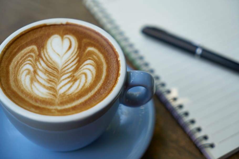 white ceramic cup filled with latte, coffee, pen, notebook HD wallpaper
