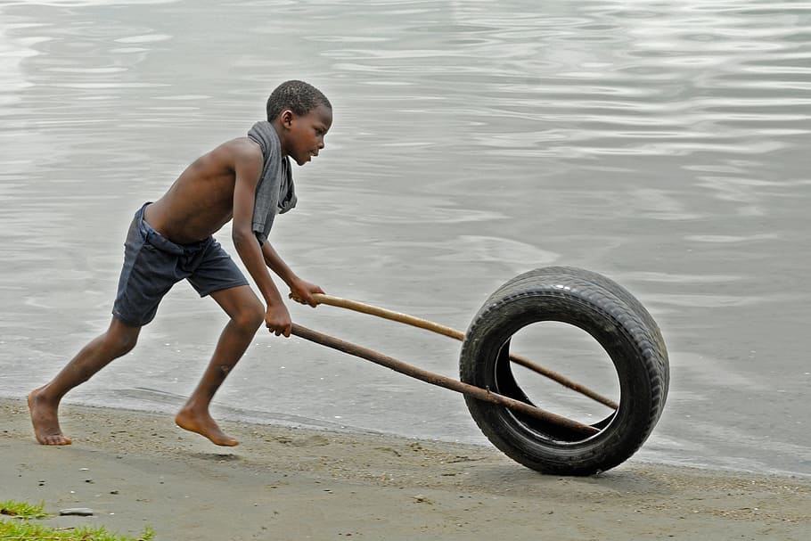 boy playing with tire at waterside, ghana, beach, full length HD wallpaper