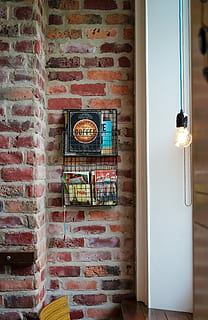 assorted magazines on gray metal wall rack, light bulb near black rack HD wallpaper