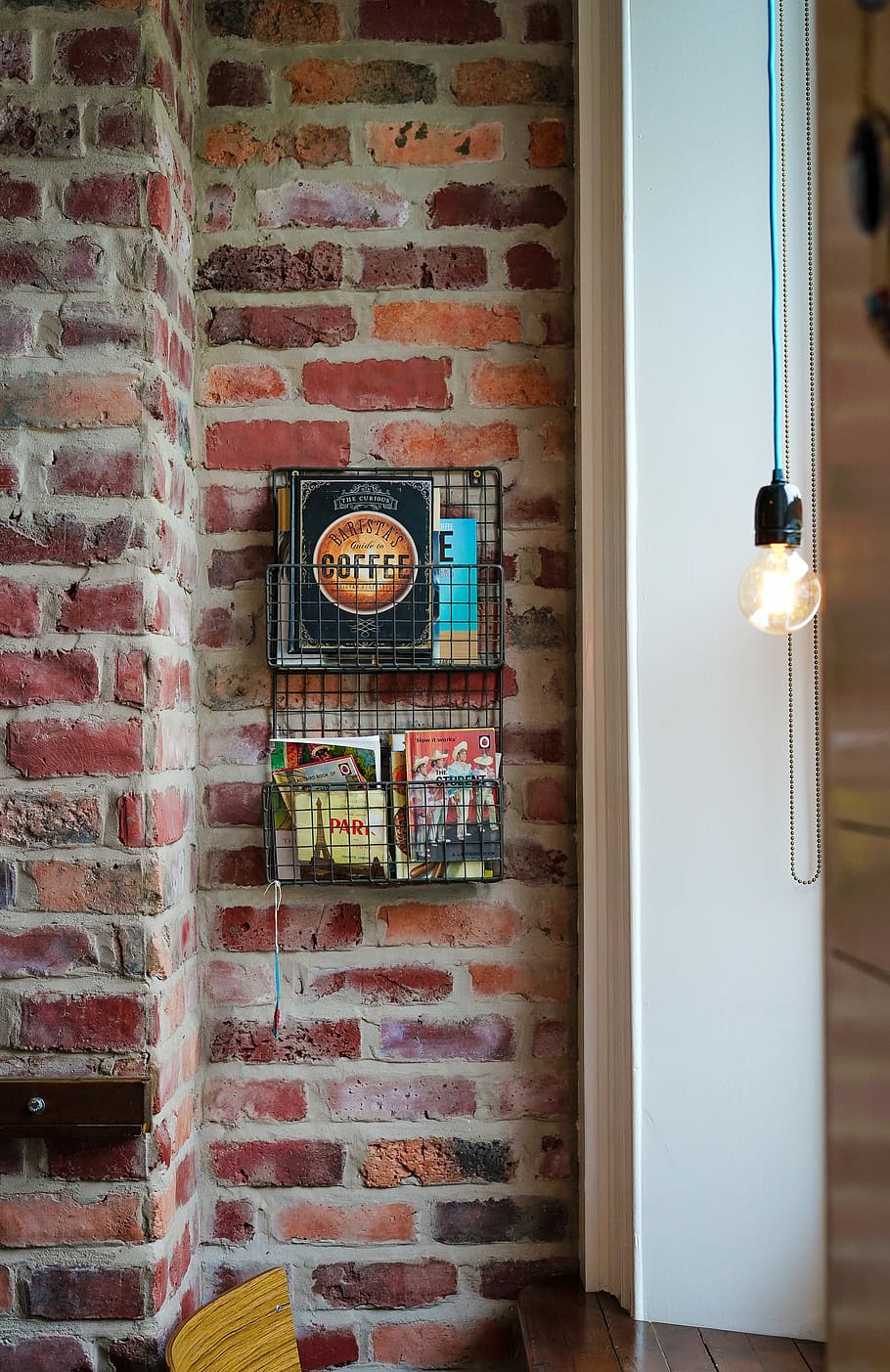 assorted magazines on gray metal wall rack, light bulb near black rack HD wallpaper