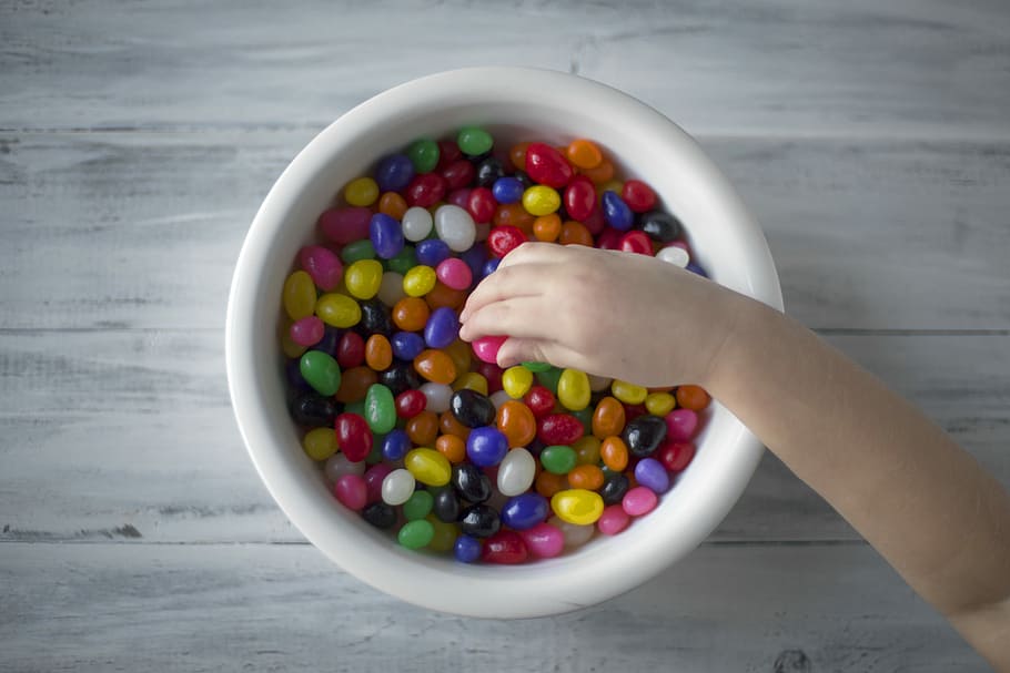 multicolored candies on white ceramic bowl, photo of person holding pebbles HD wallpaper