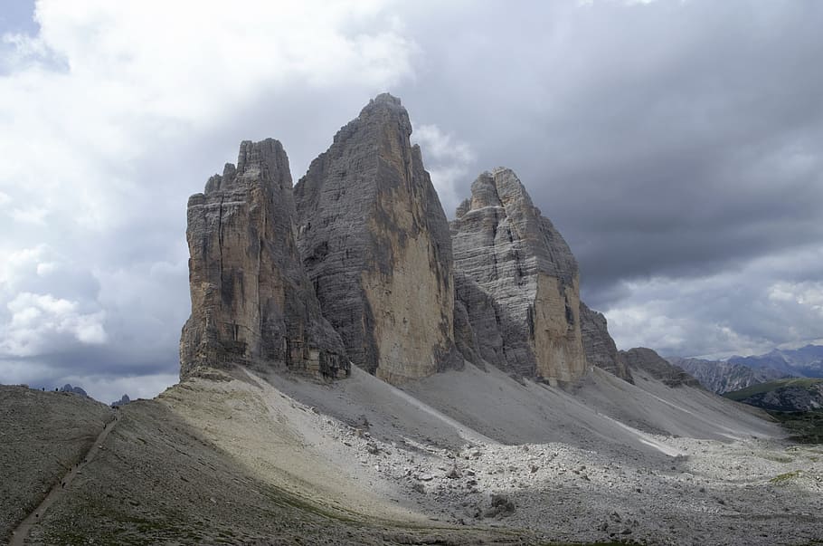 low-angle photography of gray rock under gray clouds, tre cime di lavaredo
