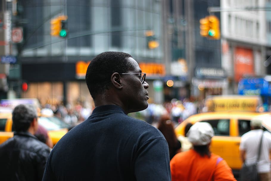 selective focus photography of man standing near road and buildings surrounded with crowd, man standing on crowd HD wallpaper