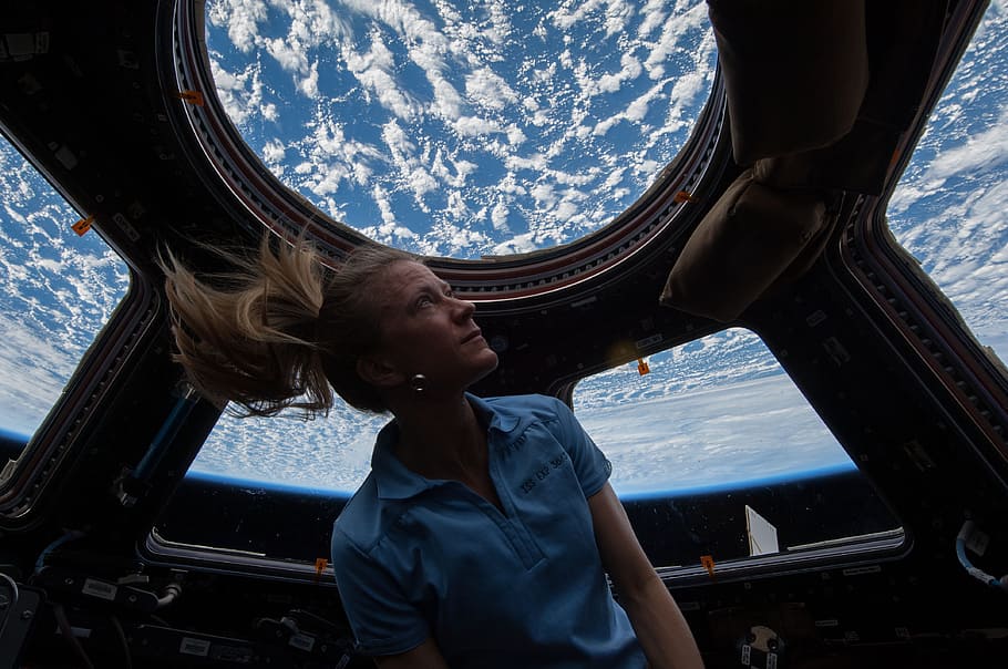 woman riding space craft, astronaut, cupola, international space station