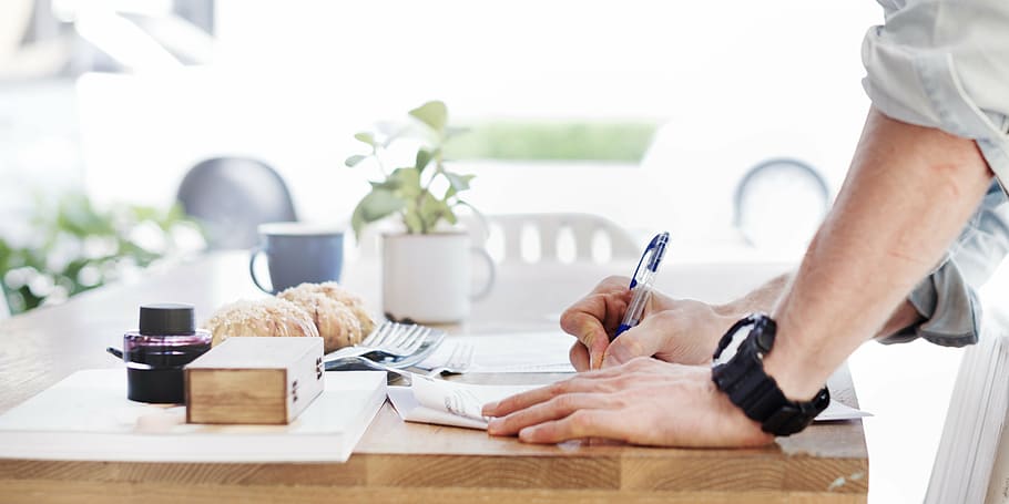 person writing on table, book, bread, bright, bun, cafe, casual HD wallpaper