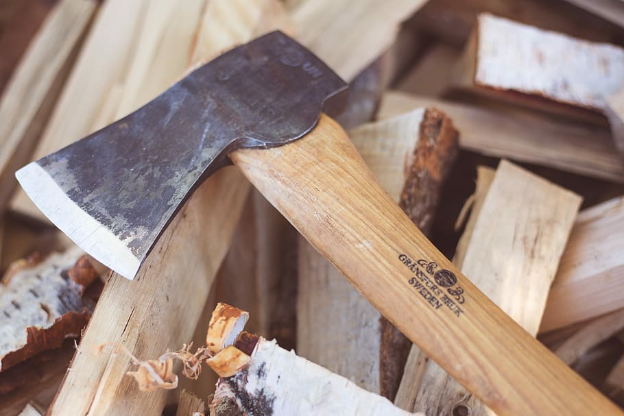 closeup photo of brown hatchet, beige wooden handle axe, wood chopping