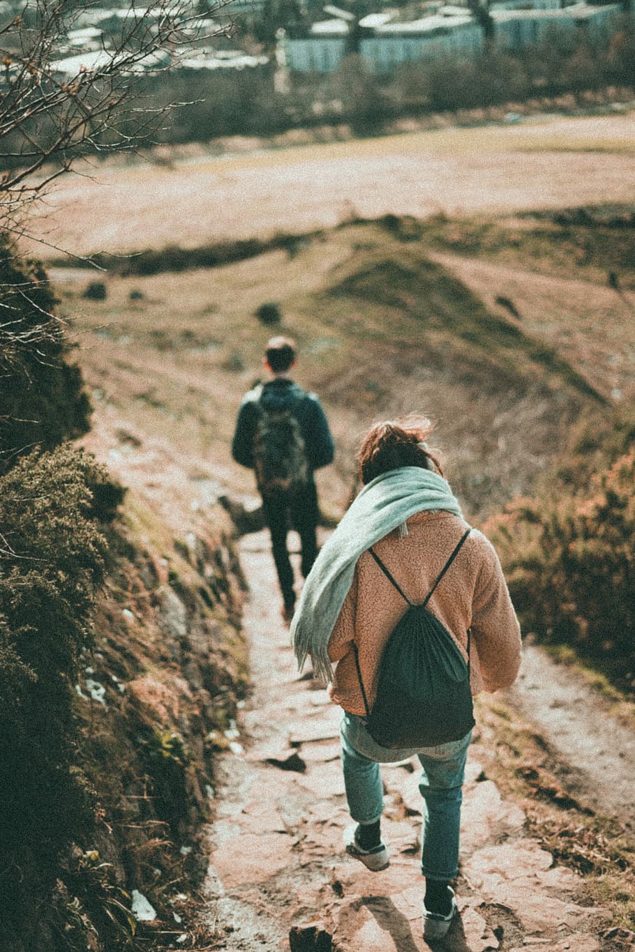 woman in blue jeans walking downhill, man and woman walking on dirt road during daytime HD wallpaper