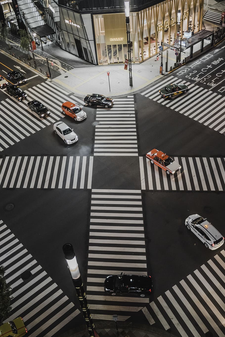 aerial view photo of vehicles crossing road, cars on street near building at nighttime HD wallpaper
