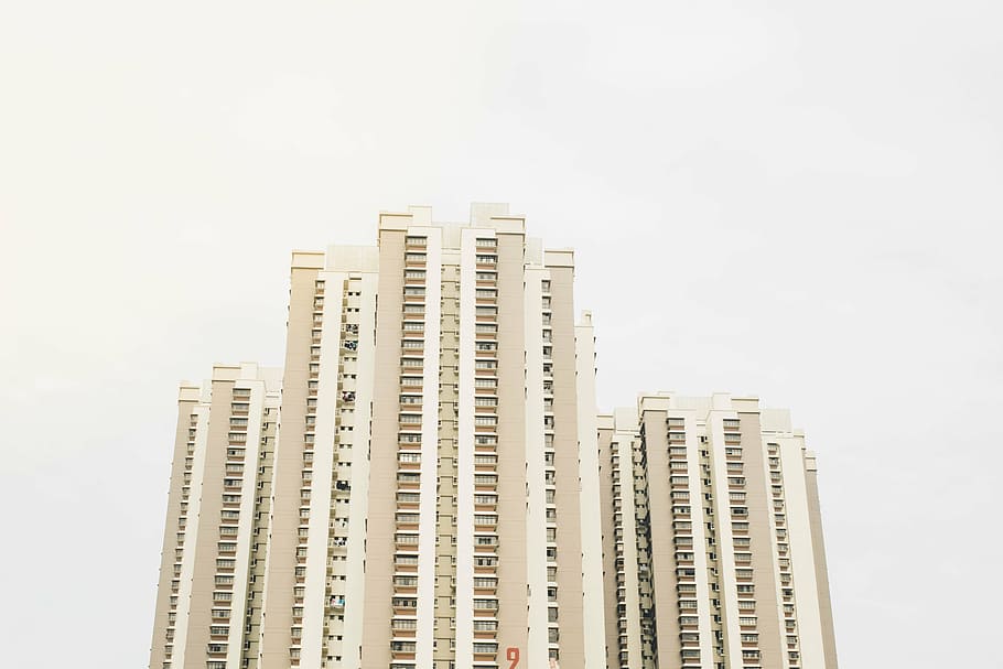 low angle photo of beige high-rise building over cloudy sky at daytime HD wallpaper