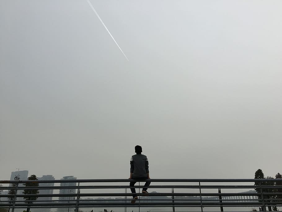man sitting on gray bars under gray sky, guangzhou university city, HD wallpaper