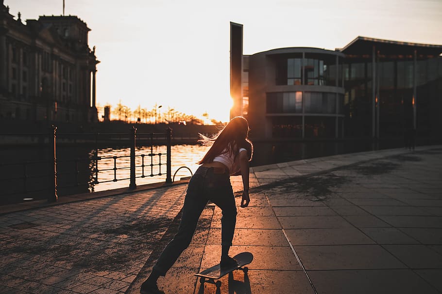 woman playing skateboard near river during daytime, woman riding on skateboard, HD wallpaper