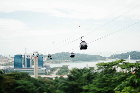 four white cable cars near blue building, assorted-color cable cars HD wallpaper