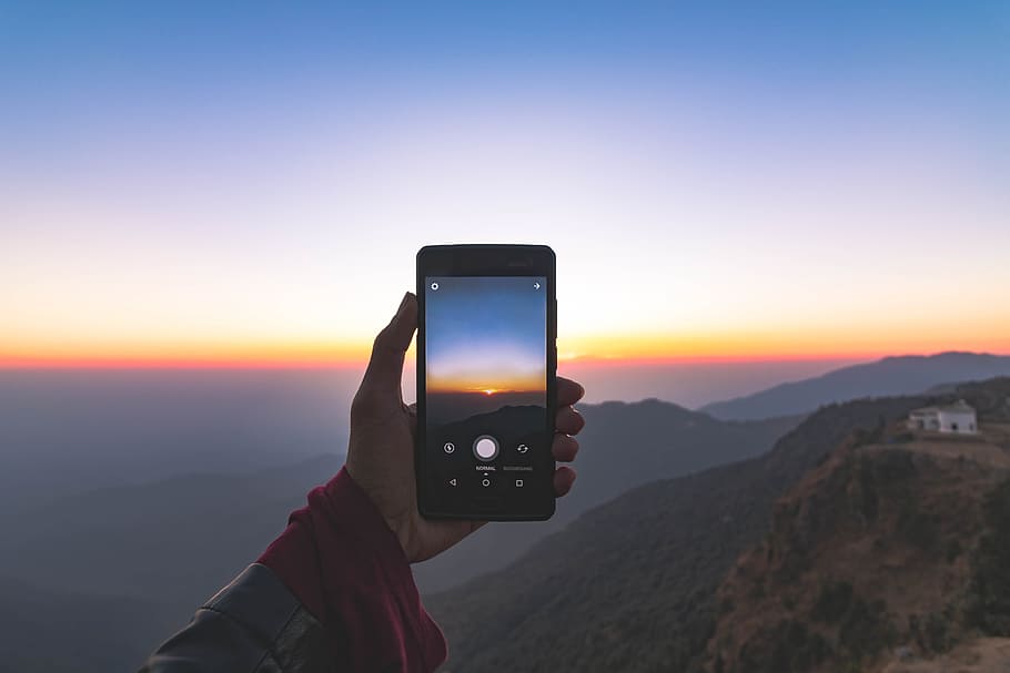 person uses smartphone, person taking photo of divided orange and blue skies over mountains near white house on mountain hill, HD wallpaper