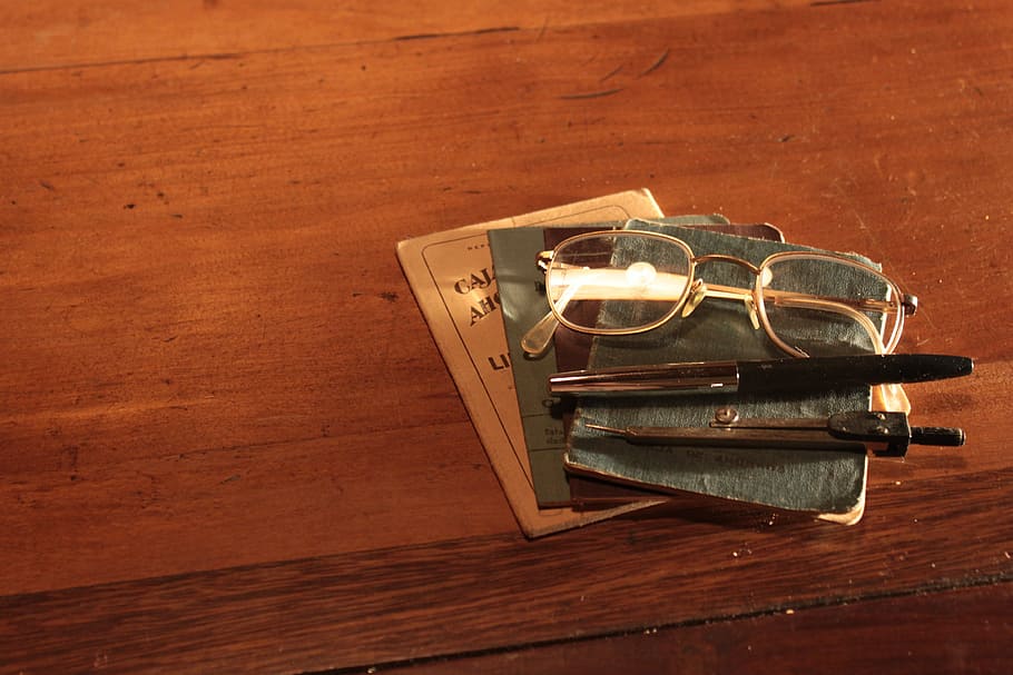 gold-colored framed eyeglasses near two click pens, lenses HD wallpaper