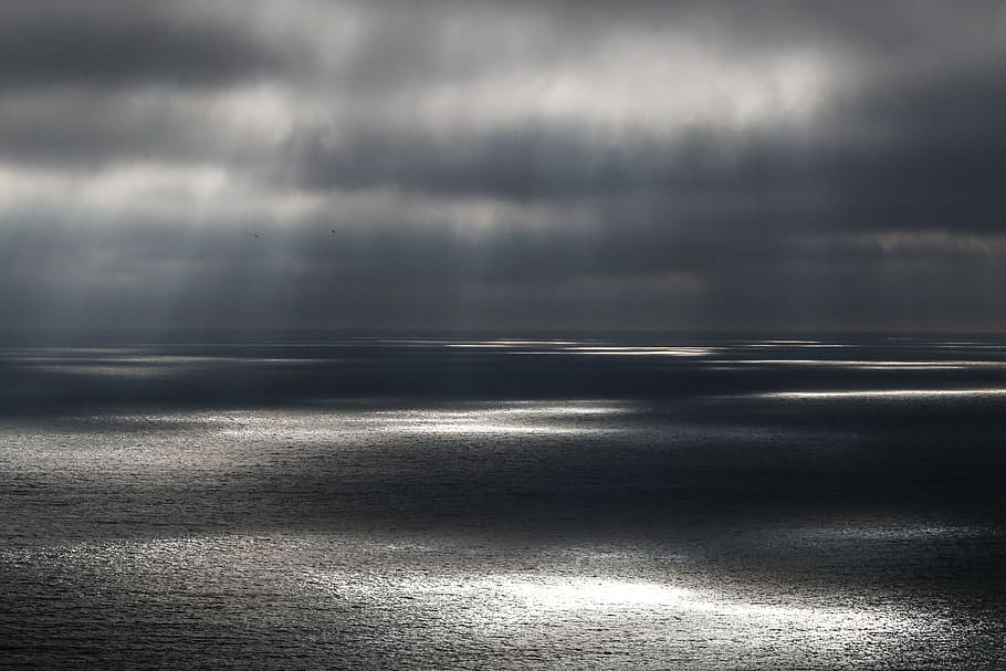 body of water under gray cloudy sky, body of water with sun rays HD wallpaper