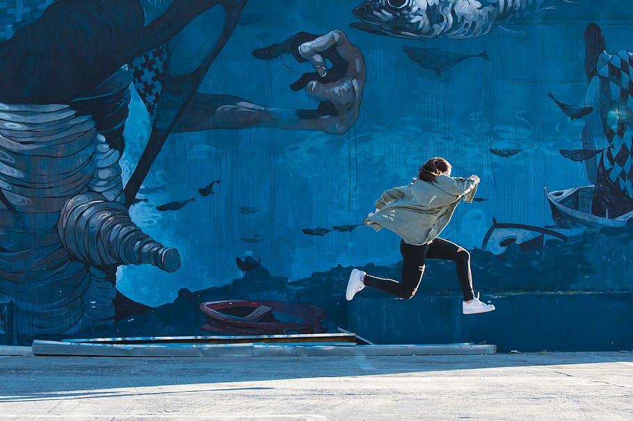 boy jumping near wall, woman in black pants jumping under sunny sy HD wallpaper